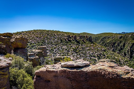 Chiricahua National Monument features nearly 12,000 acres of Rhyolite pinnacles, some rising hundreds of feet in the air, and is known as the \