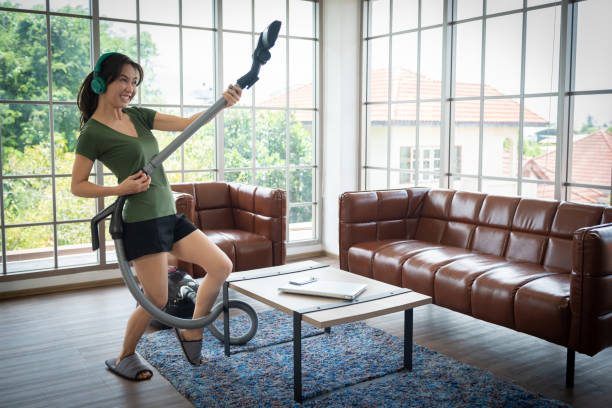 woman with vacuum cleaner in room. - appliance living room domestic room lifestyles imagens e fotografias de stock
