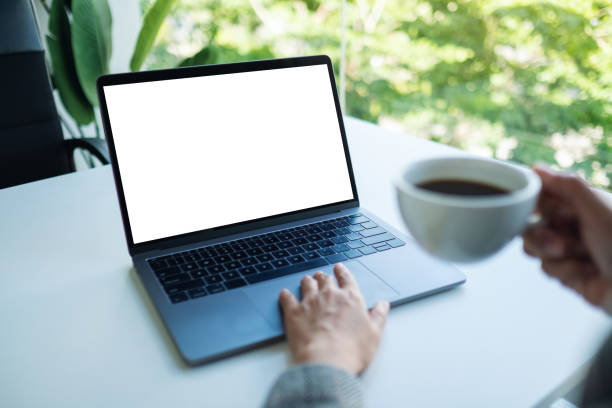 istock a businesswoman using and touching on laptop touchpad with blank white desktop screen while drinking coffee in office 1262092749