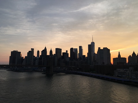 New York City Skyline with Brooklyn Bridge, Manhattan Financial District and World Trade Center, Illuminated at Night, Water of East River and Vivid Yellow Orange Blue Sunset Sky. Canon EOS 6D (full frame sensor) DSLR and Canon EF 24-105mm F/4L IS lens. HDR image.