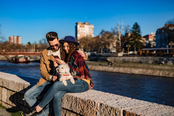istock Couple with dog enjoying on riverbank 1262096708
