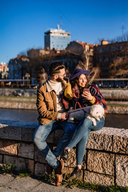 Couple with dog enjoying on riverbank