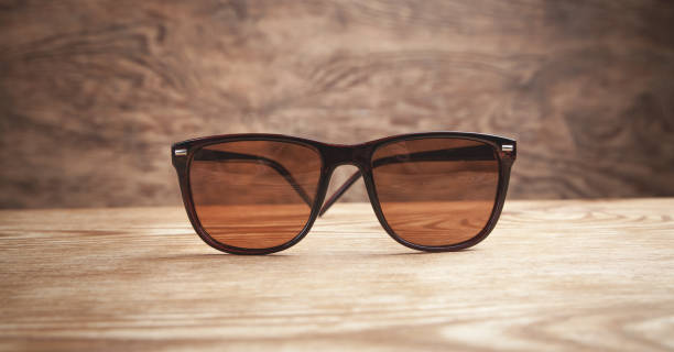 istock Brown sunglasses on the wooden background. 1262111705