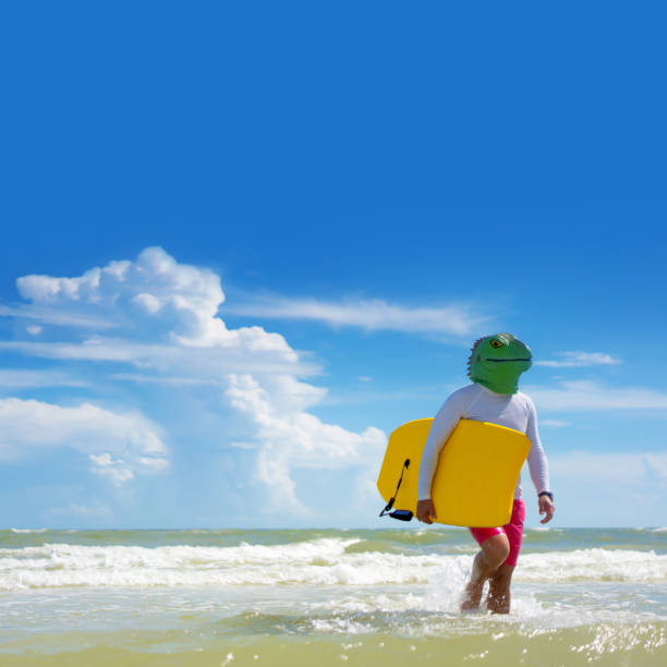 istock Wearing a lizard mask holding skimboard on a beach in Miami 1262120600