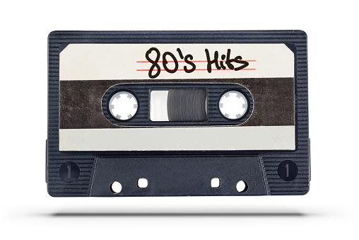 Audio record. Old tape compact cassette with 80's hits text isolated on white background