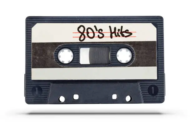 Audio record. Old tape compact cassette with 80's hits text isolated on white background