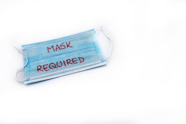 istock Single use medical face mask with handwritten message Mask Required isolated over white background, coronavirus protection concept 1262150069