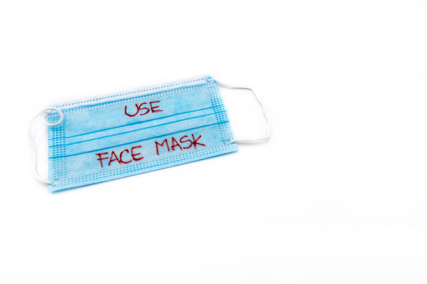 istock Single use medical face mask with handwritten message Use Face Mask isolated over white background, coronavirus protection concept 1262150347