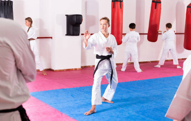 istock Preteen boy practicing karate movements with male trainer supervision 1262160037
