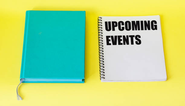 istock Message upcoming events concept on notebook with pen and notepad on yellow table 1262168016