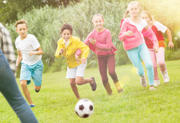 istock Kids playing football in park 1262168049