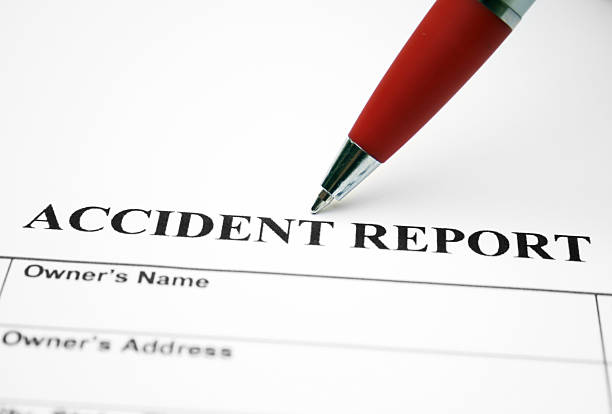 Close-up of red ballpoint pen pointing at accident report stock photo