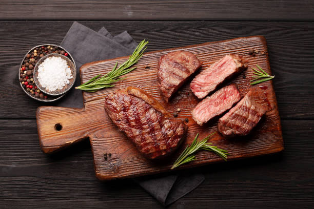 bifes de carne grelhada na tábua de corte - strip steak steak barbecue grill cooked - fotografias e filmes do acervo