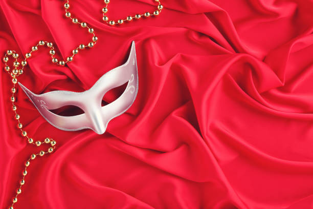 istock Carnival mask with beads on red fabric background 1262201356