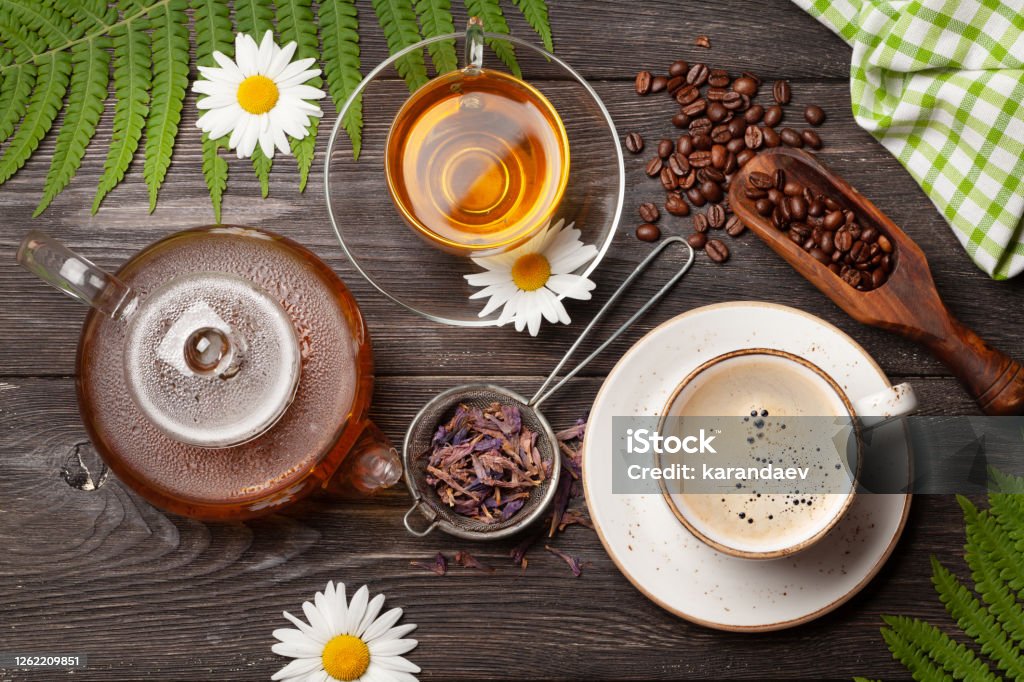 Herbal tea and espresso coffee Herbal tea in teapot and cup and espresso coffee on wooden table. Top view. Flat lay Tea Crop Stock Photo