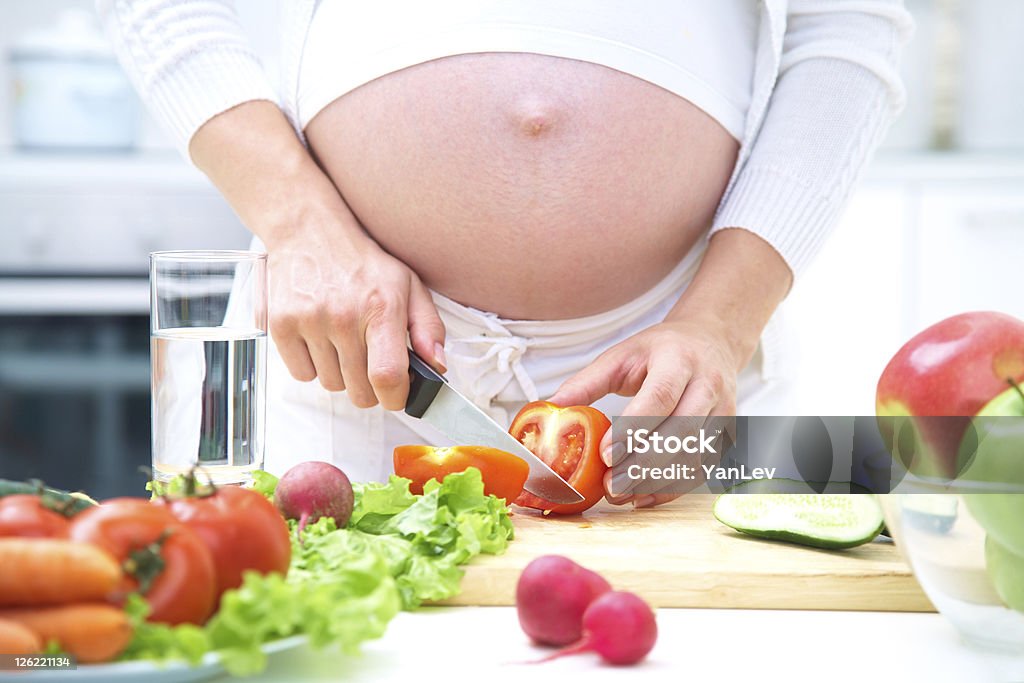 Femme enceinte de cuisson - Photo de Abdomen libre de droits