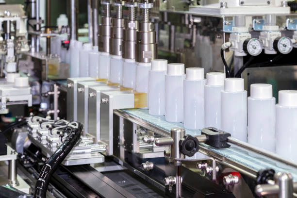 white plastic bottle moving on conveyor belt of auto capping and labeling machine at cosmetic and skincare manufacturing. cosmetic industry and ai technology machinery concept.