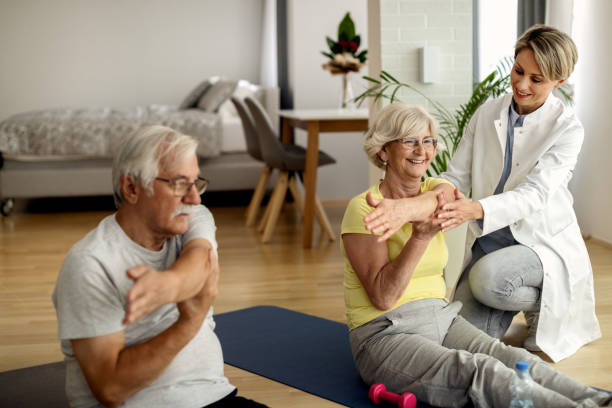 istock Physical therapist assisting senior couple with home workouts. 1262218236