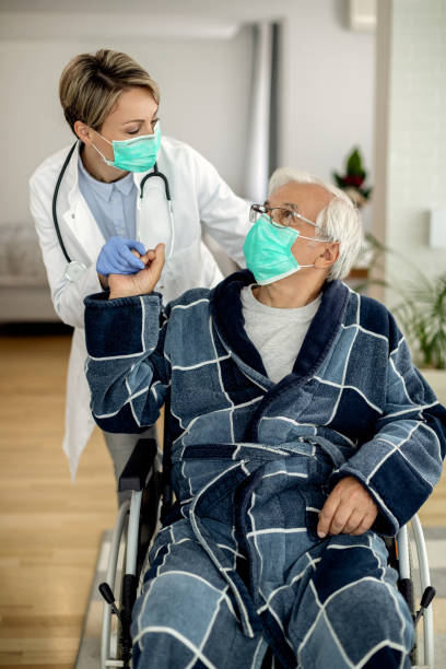 istock Home caregiver visiting senior man at home during coronavirus lockdown. 1262219166