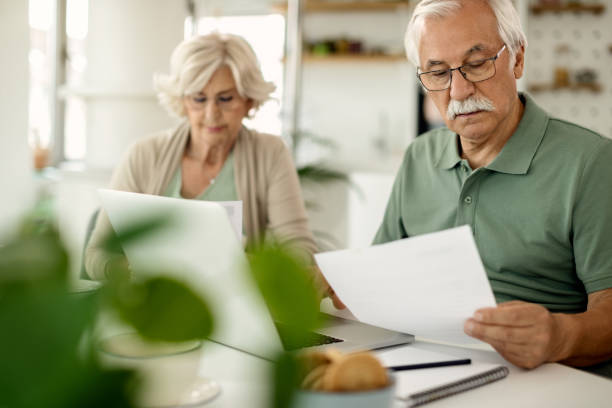 istock Mature couple analyzing their financial bills while paying them online at home. 1262237998