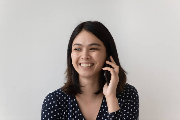 istock Smiling Asian girl laugh talking on cellphone 1262241376