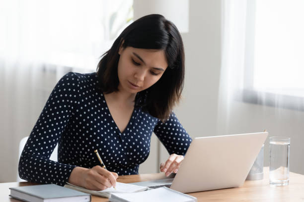 istock Focused Asian girl study on laptop making notes 1262241392