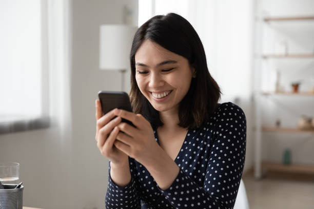 istock Smiling Vietnamese girl texting on modern smartphone 1262241425