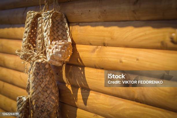 Birchen Woven Bast Shoes Hang On A Log Wall Selective Focus Stock Photo - Download Image Now