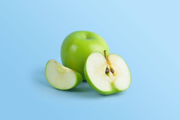 le mele verdi sono disposte in modo tale da essere sia mezzo pieno che semi-diviso e sono un frutto popolare per coloro che perdono peso - half full apple green fruit foto e immagini stock