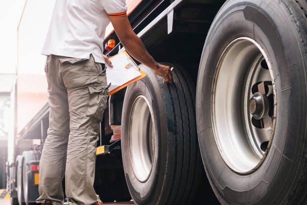 クリップボードを持つトラックの運転手は、トラックの車輪とタイヤの安全性をチェックします。 - flatbed truck truck truck driver heavy ストックフォトと画像