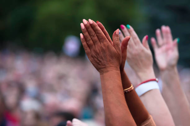 その黒人は抗議して手を挙げた。社会正義と平和的な抗議人種的不正。ぼやけた群衆の背景に合わせて一緒に黒と白の手。 - fighting female conflict white ストックフォトと画像