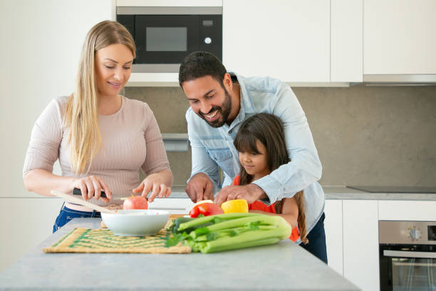 istock Cheerful mom and dad teaching kid to cook 1262251071