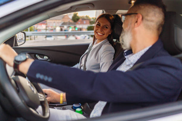 istock Smiling driver talking with elegant businesswoman. 1262254587