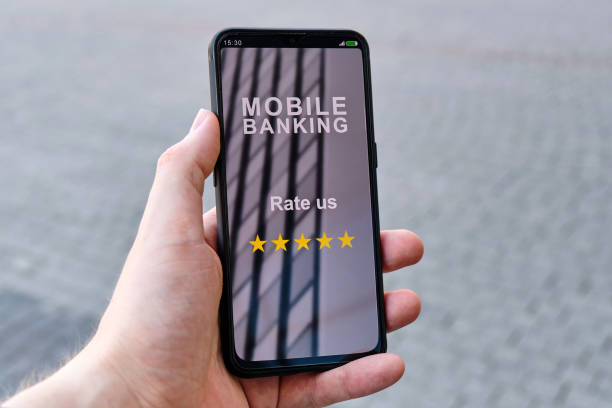 istock Hand holds smartphone with mobile banking interface and inscription rate us with 5 stars 1262257384