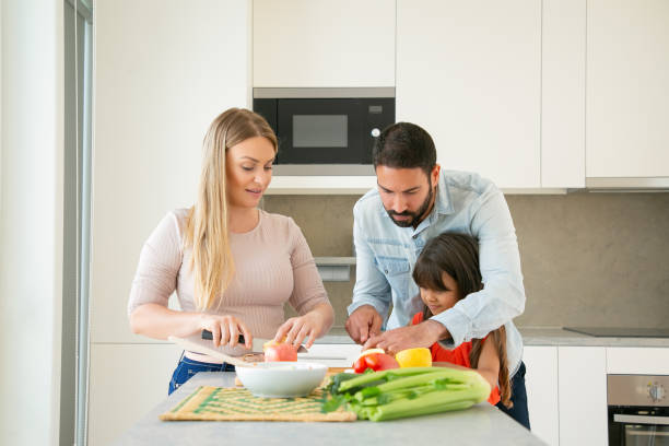 istock Mom and dad teaching kid to cook 1262264062