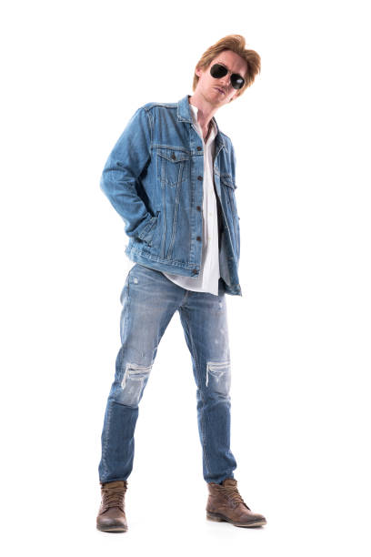 istock Curious young stylish man in jeans with hands in jacket pockets looking at camera with suspicious. 1262266856