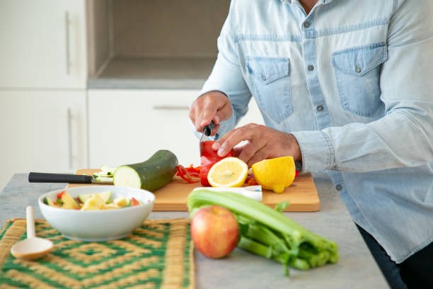 istock Hands of man cooking salad, cutting fresh vegetables 1262269799