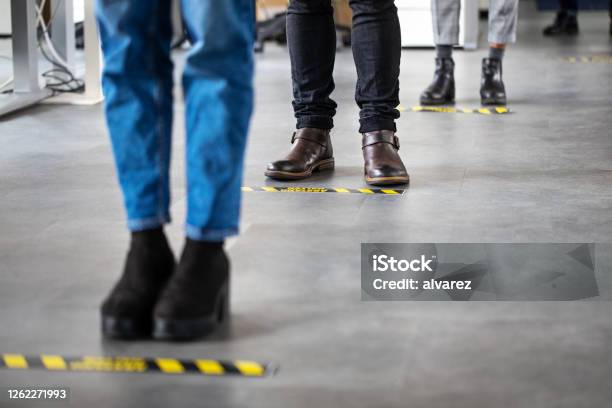 Business People Standing Behind Social Distancing Signage On Office Floor Stock Photo - Download Image Now