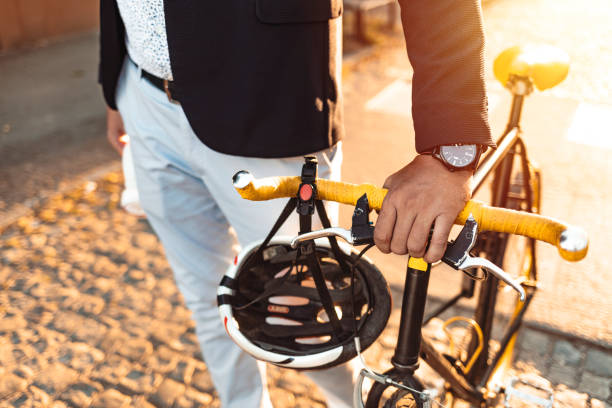 Businessman walking to office taking his bicycle along. Man enjoying while walking to work along with his bike.
