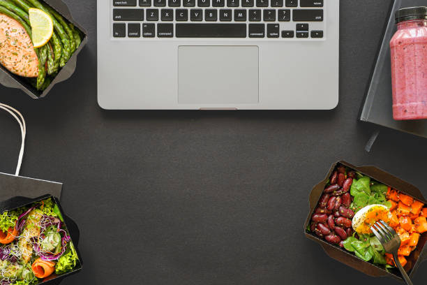 istock Office food delivery takeout lunch boxes containers delivered in office on black table workplace. Ready take away snack daily healthy meal dinner at work desk flat lay desktop top view, copy space. 1262278869