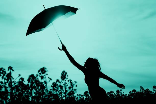 istock Unplugged free silhouette woman has umbrella up to turquoise sky 1262279607