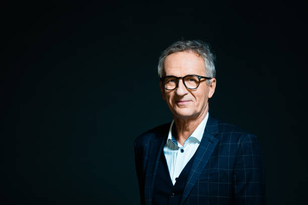 Elegant senior man Fashion portrait of elegant senior man wearing white shirt and dark suit, smiling at camera. Studio shot, black background. old rich white guy stock pictures, royalty-free photos & images