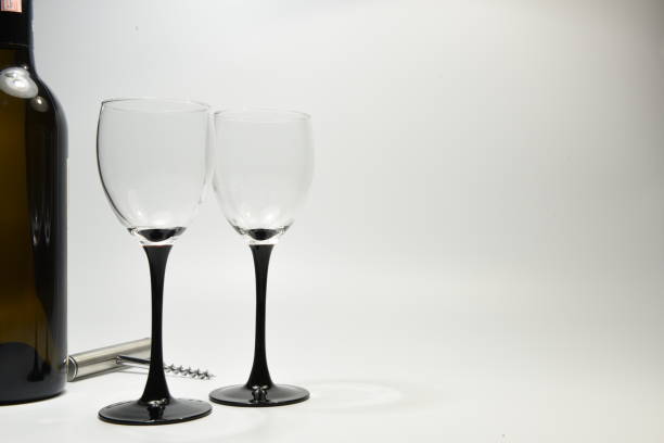 Wine glasses Two wine glasses along with a wine bottle and wine bottle opener against a white backdrop sabby stock pictures, royalty-free photos & images