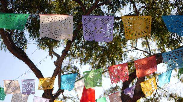 bunte mexikanische perforierte papel picado banner, festival bunte papier girlande. bunte hispanische folk geschnitzt gewebe fahnen, urlaub oder karneval. authentische fiesta dekoration in lateinamerika - mexico mexican culture carnival paper stock-fotos und bilder