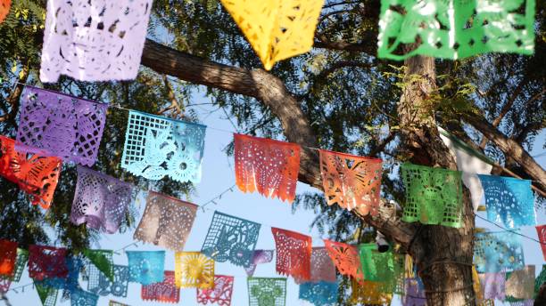 bunte mexikanische perforierte papel picado banner, festival bunte papier girlande. bunte hispanische folk geschnitzt gewebe fahnen, urlaub oder karneval. authentische fiesta dekoration in lateinamerika - mexico mexican culture carnival paper stock-fotos und bilder