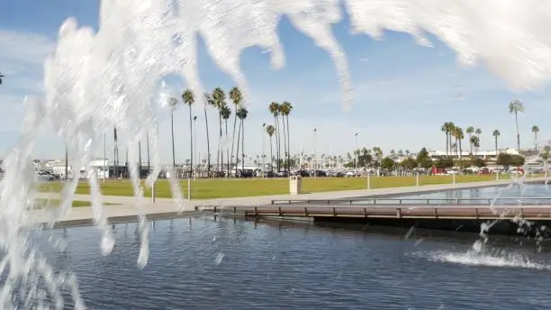 Fountain in waterfront city park near San Diego county civic center in downtown, California government authority, USA. Pacific ocean harbour, embarcadero in Gaslamp Quarter. Palms and grass near pier.