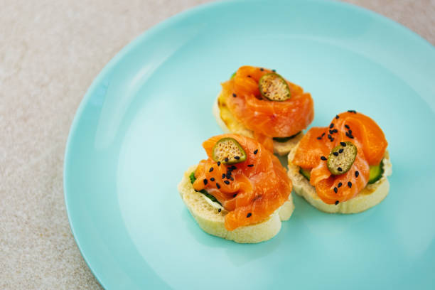 istock Canape snacks with red salmon fish fillet & capers served on blue ceramic plate for dinner. 1262286687