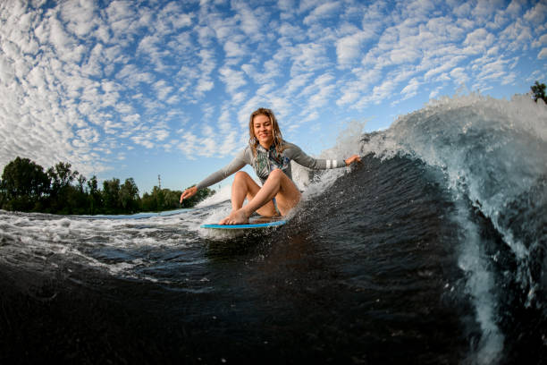 istock handsome blond woman riding the waves while sitting on wakesurf board 1262288162
