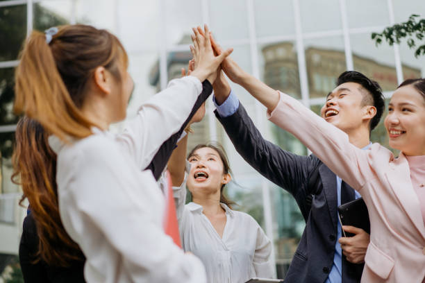 istock Cheerful business people arms raised and high five 1262289074