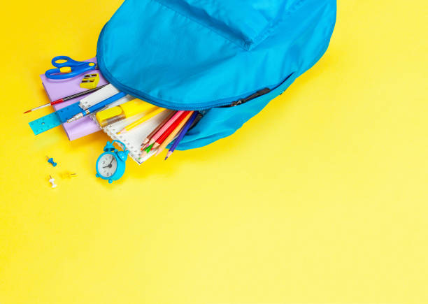 istock School bag. Backpack with supplies for school on yellow background. Copy space for text 1262289391